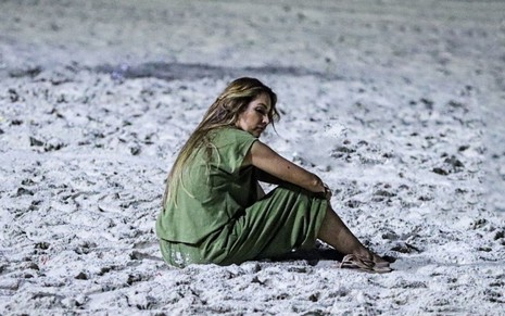 Patrícia Poeta sentada na areia da praia