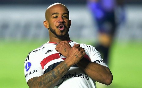Patrick, do São Paulo, comemora gol com braços cruzados com uniforme branco com listras vermelha e preta