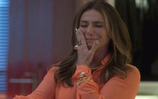 A atriz Giovanna Antonelli com mão no rosto, limpando as lágrimas, chorando, em cena de Quanto Mais Vida, Melhor!