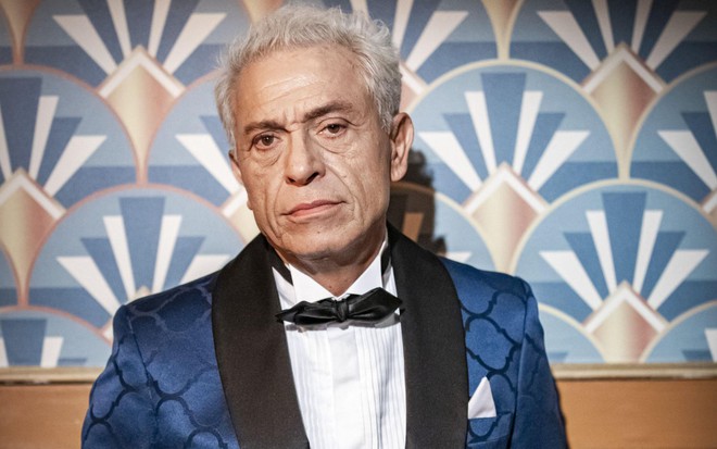 O ator Paulo Gorgulho com expressão séria, caracterizado como Leonel em Amor Perfeito
