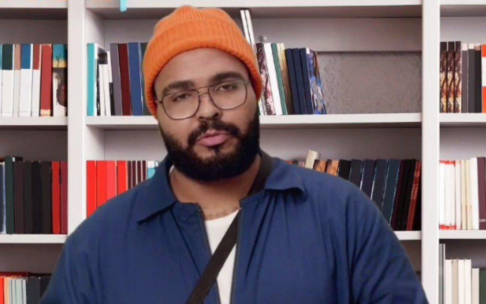 Paulo Vieira caracterizado com touca laranja e camisa azul em vídeo