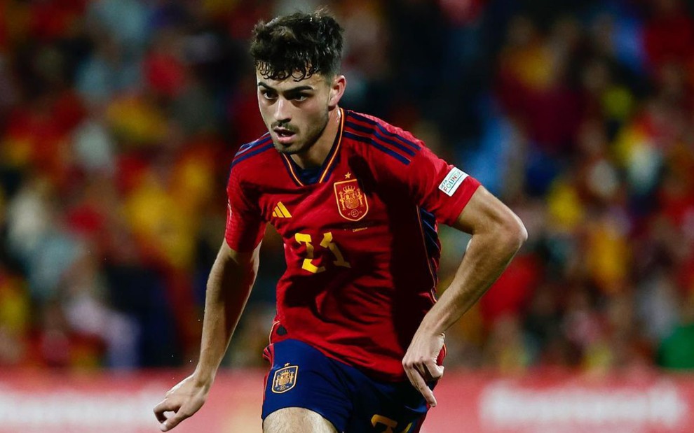 Pedri, veste uniforme vermelho com detalhes amarelos durante partida da seleção espanhola