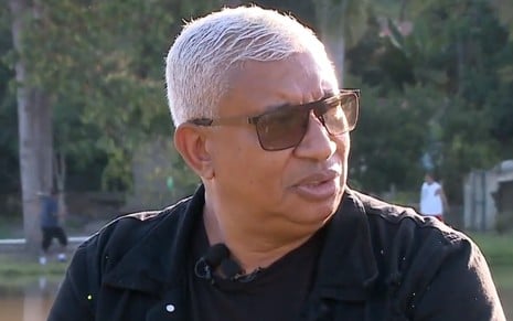Pedro Manso de roupa preta e cabelos brancos em entrevista ao Fofocalizando