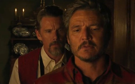 Ao fundo, Ethan Hawke olha para Pedro Pascal, à frente