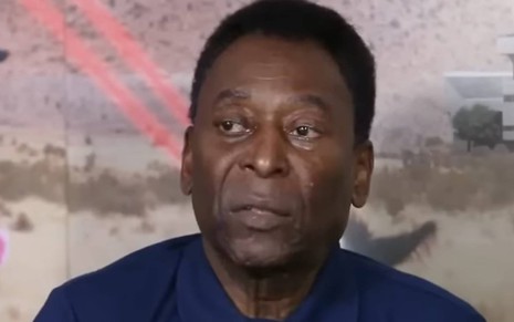 Foto de Pelé; ele olha para o lado e veste camiseta azul