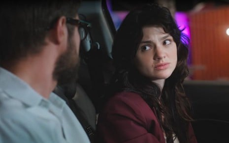 Em cena de Terra e Paixão, Rafael Vitti usa blusa azul e está conversando com Debora Ozório dentro de um carro