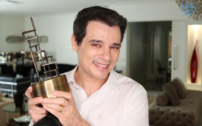 Emocionado e com sorriso no rosto, Celso Portiolli exibe o troféu de melhor apresentador do Prêmio Notícias da TV 2021