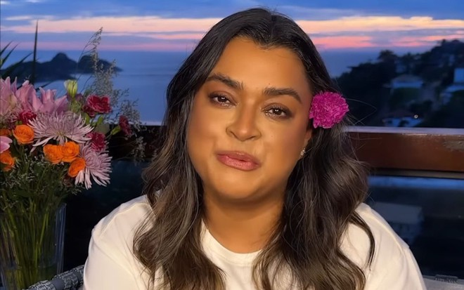 Preta Gil com uma flor rosa na orelha