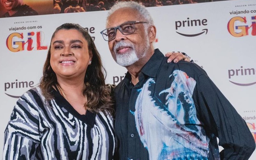 Preta e Gilberto Gil estão abraçados, em evento de lançamento da Amazon