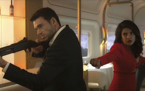Richard Madden segura uma espingarda e Priyanka Chopra Jonas faz pose de ação em cena de Citadel