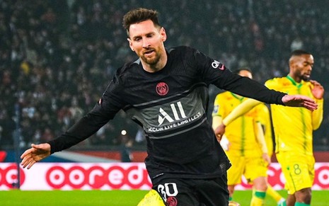 Messi vestindo uniforme preto com detalhes cinza e branco, comemorando gol durante partida de futebol