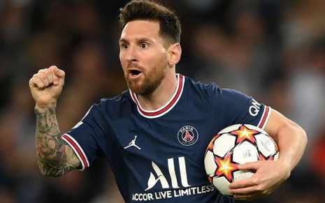 Jogador Lionel Messi, do PSG, comemora gol com a bola na mão e veste uniforme azul com detalhes brancos