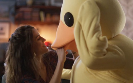 A atriz Luciana Paes como Odete ajuda Fábio Herford, o Juca, a vestir uma fantasia de pato em cena de Quanto Mais Vida, Melhor