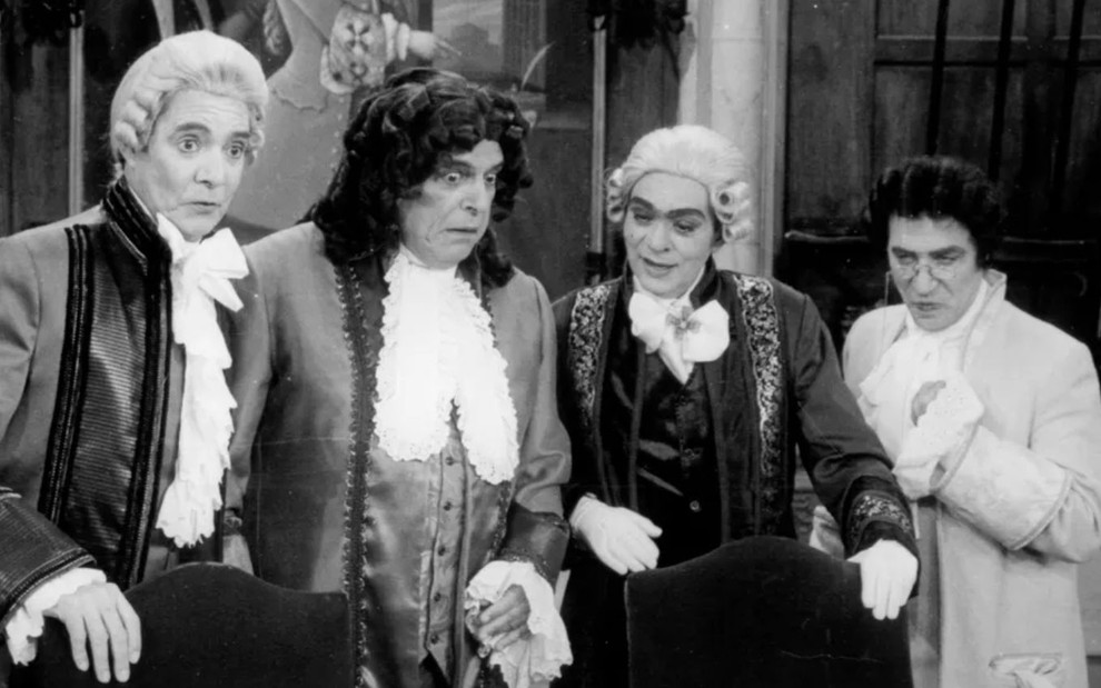 Foto preto e branco com os atores John Herbert, Oswaldo Loureiro, Chico Anysio e Laerte Morrone na novela Que Rei Sou Eu? (1989)
