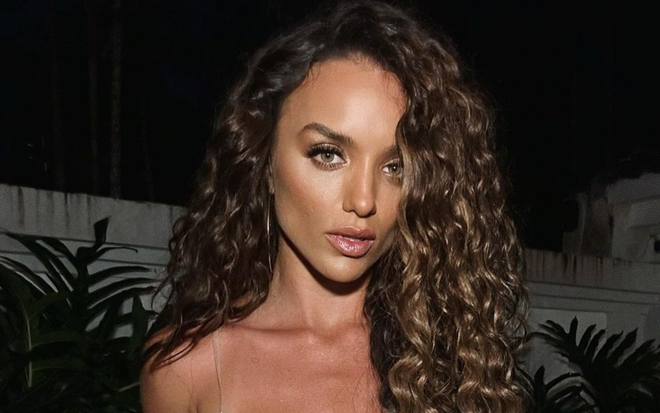 Rafa Kalimann usa uma blusa branca decotada e cabelo cacheado