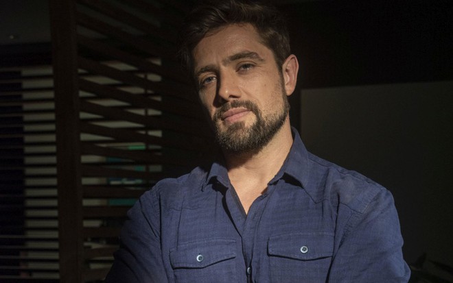 Rafael Cardoso usa blusa de botão azul escuro