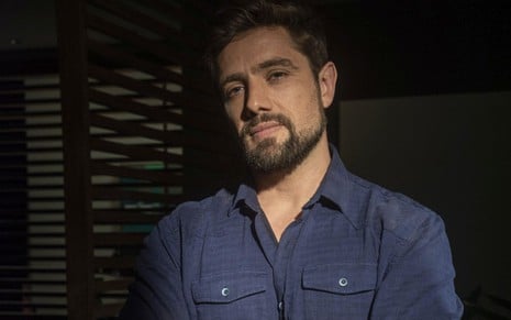 Rafael Cardoso usa blusa de botão azul escuro