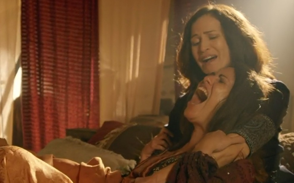 A atriz Giselle Tigre faz cara de dor ao lado de Ingra Lyberato em cena da novela Gênesis
