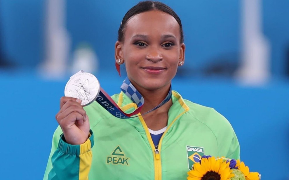 Com uniforme verde e amarelo da ginástica, Rebeca Andrade exibe medalha de prata conquistada nas Olimpíadas