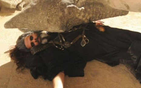 Marcos Winter grava cena caído no chão, sendo esmagado por uma estátua, como Merodaque