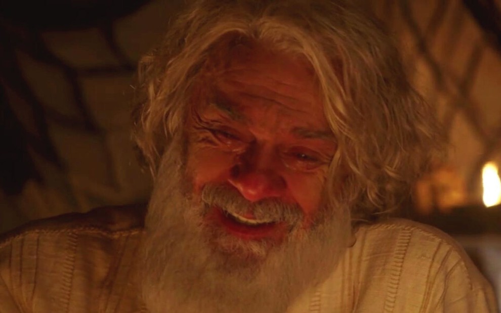 Zécarlos Machado em cena de Gênesis: caracterizado como Abrão, ator está em close e com expressão de alegria no rosto
