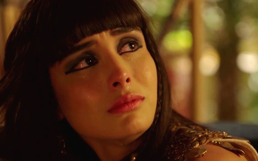Letícia Almeida em cena de Gênesis: atriz está caracterizada como Asenate, em close e olha chorando para alguém fora do quadro
