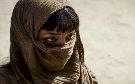 Neferíades (Dandara Albuquerque)  está com o rosto coberto no deserto em cena de Gênesis