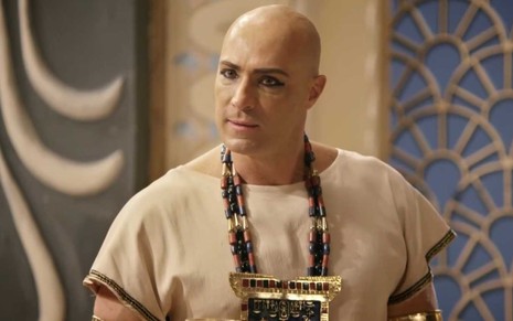 O ator Fernando Pavão caracterizado como Sheshi com uma taça de ouro na mão direita em cena de Gênesis