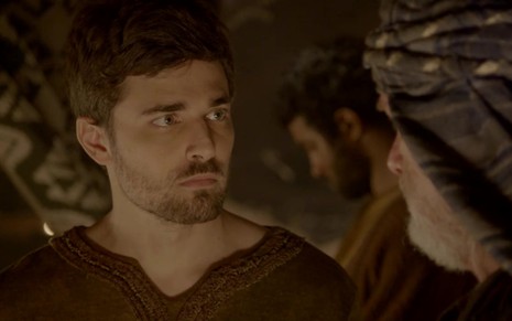 Miguel Coelho grava com expressão séria e bata marrom como Jacó, seu personagem bíblico de Gênesis