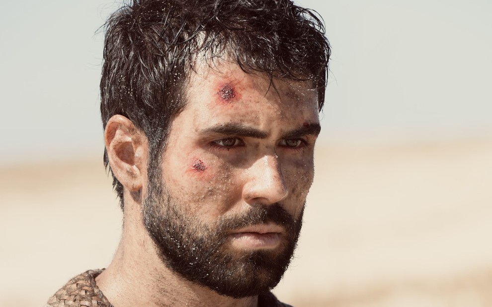 Juliano Laham grava com rosto machucado e expressão de tristeza e olhar vazio como José de Gênesis, da Record