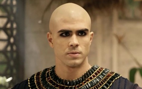 Juliano Laham em cena de Gênesis: ator está caracterizado com bata marrom com detalhes de pedraria e maquiado com delineador preto ao redor dos olhos
