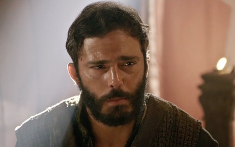 Thiago Rodrigues em cena de Gênesis: ator está caracterizado como Judá e tem olhar sério para alguém fora do quadro