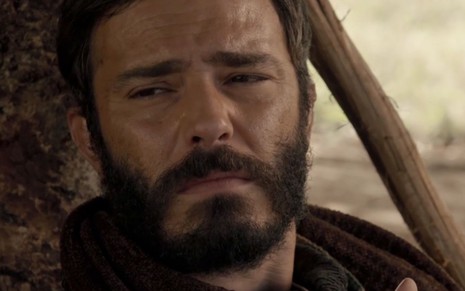 Thiago Rodrigues em cena de Gênesis: ator está caracterizado como Judá, está em close e tem olhar sério para alguém fora do quadro