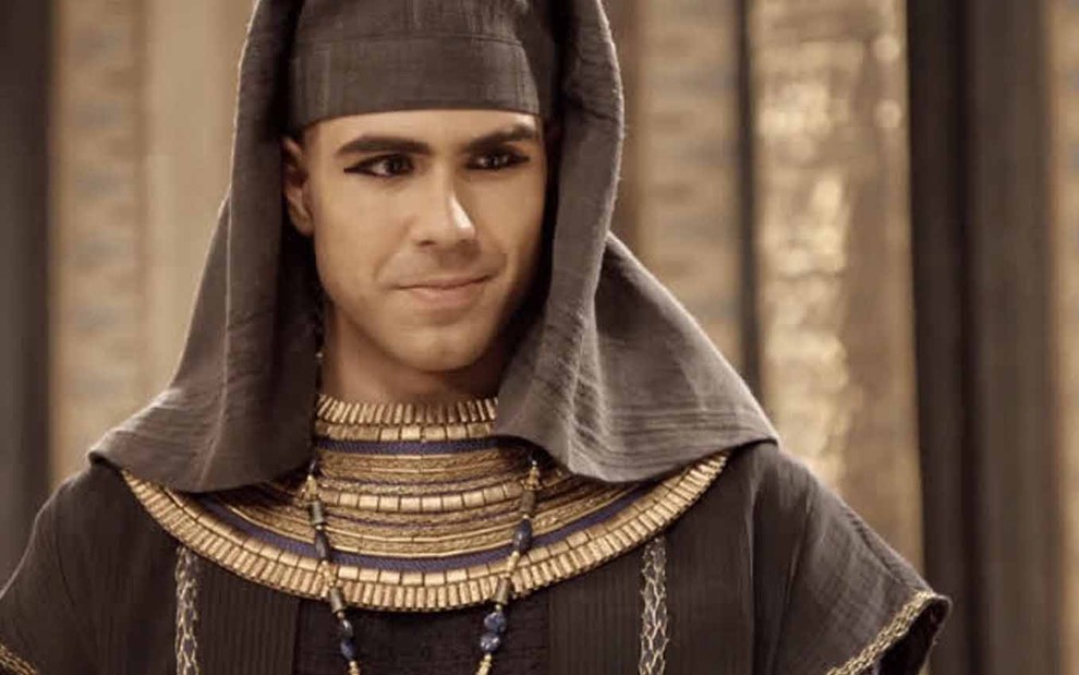 O ator Juliano Laham com barba e cabelo raspados na máquina zero, com uma roupa egípcia antiga, mais simples, de um servo, e caracterizado como José em cena de Gênesis