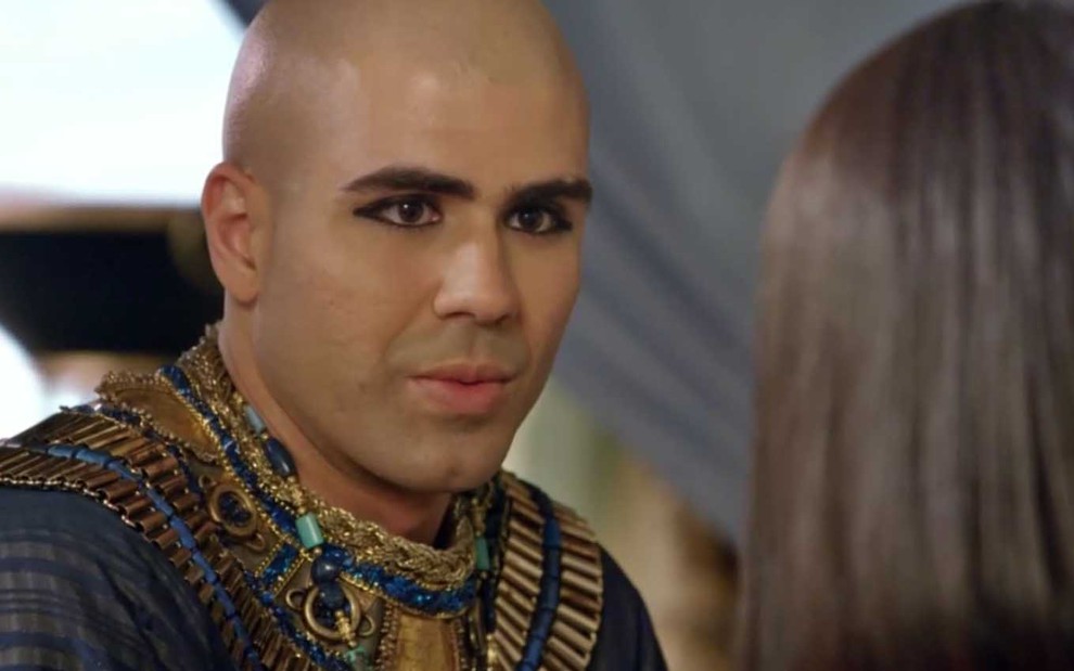O ator Juliano Laham com expressão de surpresa e caracterizado como José na fase egípcia, com os cabelos raspados e kajal nos olhos, em cena de Gênesis
