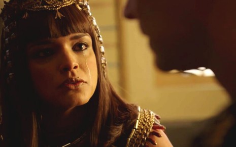 Kamesha (Kizi Vaz) chora ao conversar com Sheshi (Fernando Pavão), que aparece apenas com o queixo na foto, em cena de Gênesis