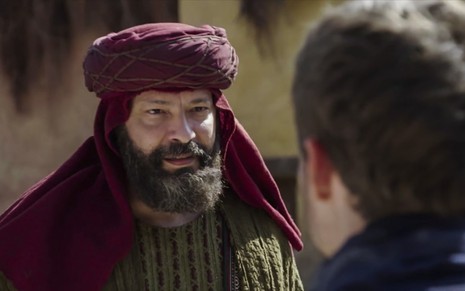 Heitor Martinez grava com turbante vermelho na cabeça e barba grande como Labão de Gênesis, da Record