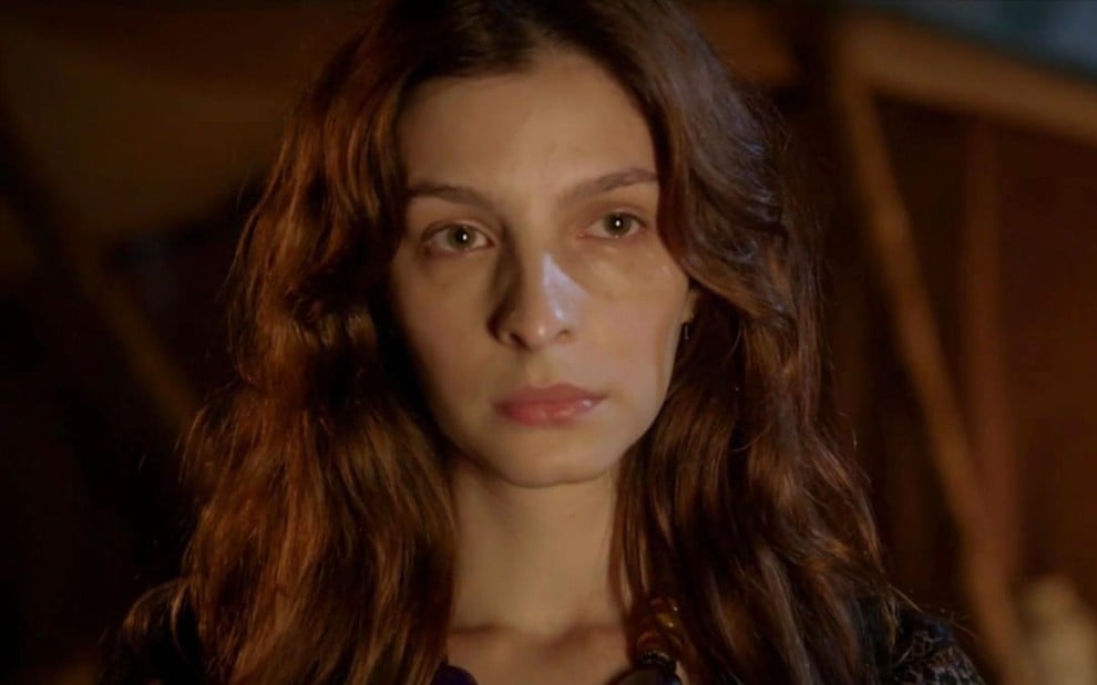 Michelle Batista caracterizada como Lia em Gênesis: atriz está com cabelo solto e olha de maneira série para alguém fora do quadro