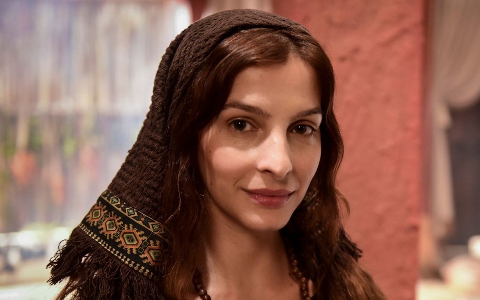 Michelle Batista caracterizada como Lia em Gênesis: atriz está com véu no cabelo e sorri