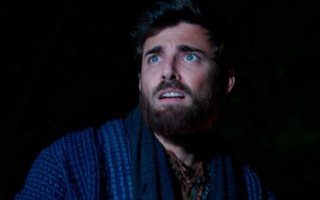 O ator Miguel Coelho caracterizado como Jacó está boquiaberto em uma cena noturna de Gênesis