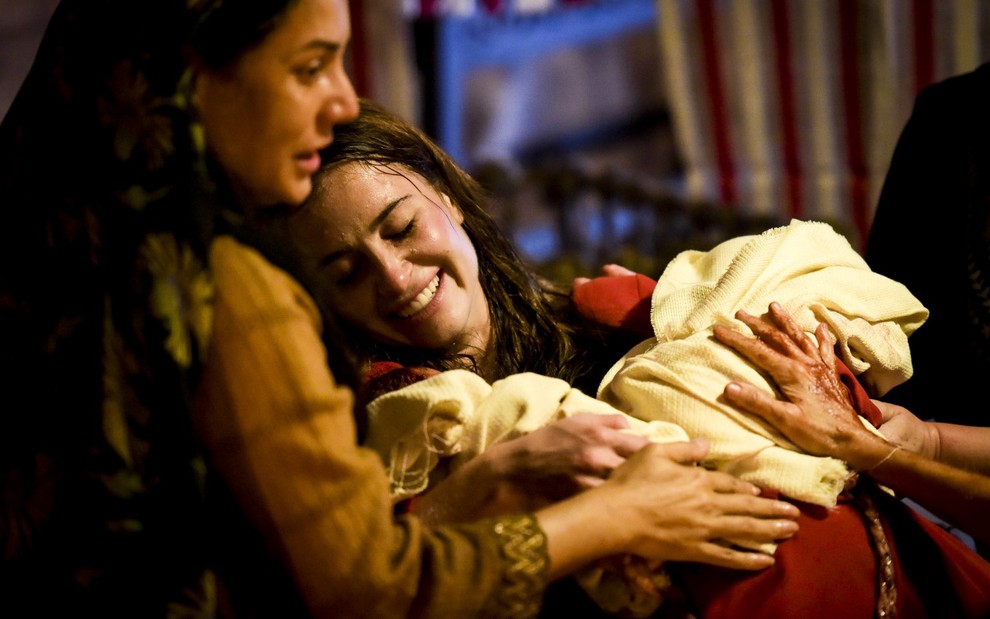 Barbara França grava suada e sorridente com dois bebês no colo como Rebeca de Gênesis, da Record