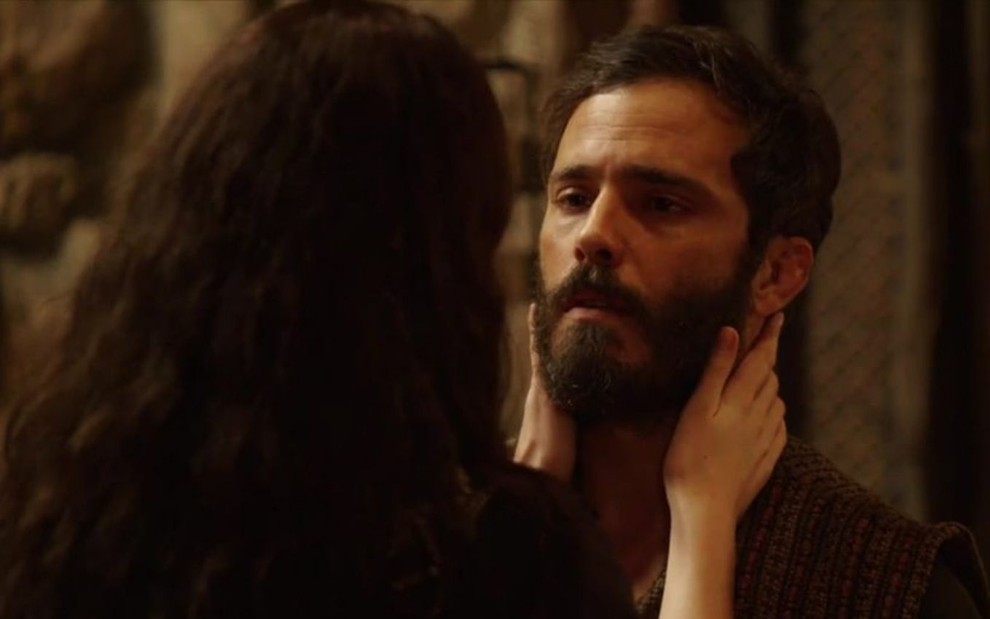 Muriel (Rhaisa Batista) está de costas, ela está com as mãos no rosto de Judá (Thiago Rodrigues) em cena de Gênesis