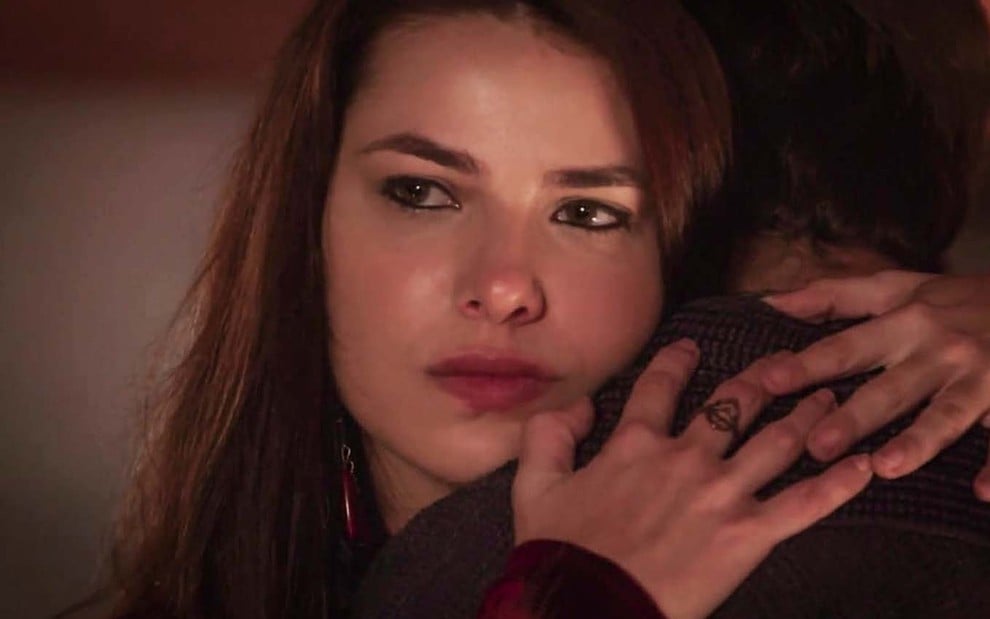 A atriz Thaís Melchior como Raquel com expressão de raiva abraça Miguel Coelho, o Jacó, de costas em cena de Gênesis