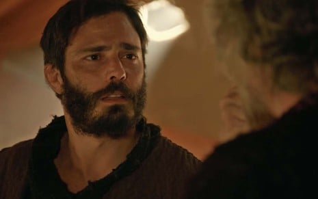 O ator Thiago Rodrigues está em uma tenda como o Judá com expressão de confusão em cena de Gênesis