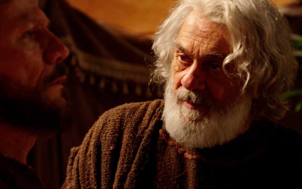 O ator Zécarlos Machado caracterizado como Abraão, com os cabelos bastante brancos e barba longa, da mesma cor, como Abraão em cena de Gênesis
