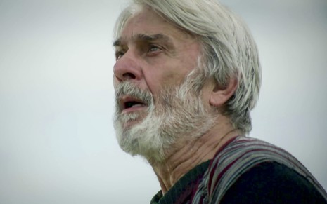 O ator Zécarlos Machado caracterizado como Abrão em cena da novela Gênesis; ele olha para o céu com expressão de clamor