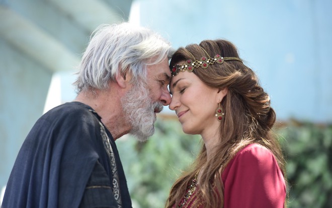 O ator Zécarlos Machado encosta seu rosto no de Adriana Garambone em cena romântica da novela Gênesis