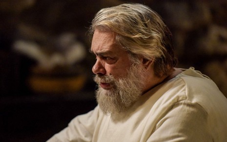José Rubens Chachá em cena de Reis: ator está com barba grisalha, túnica branca e está de perfil
