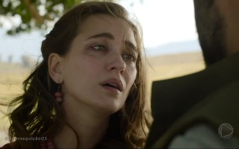 Zeruia (Juliana Boller) chora em um campo aberto em cena da novela Reis