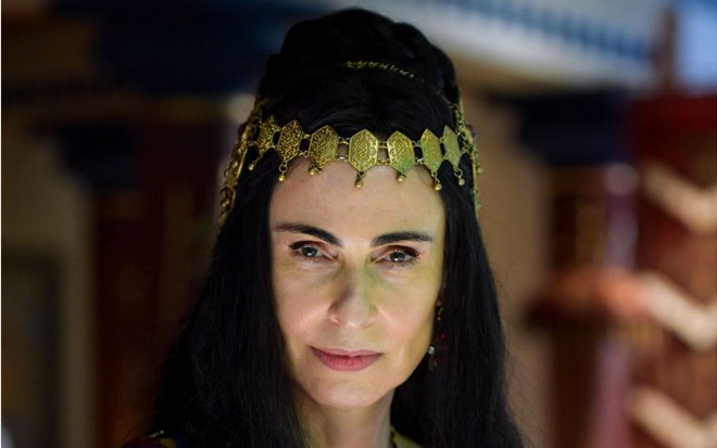 Silvia Pfeifer caracterizada como Anainér em Reis: atriz está com cabelos pretos longos e usa adorno na cabeça dourado